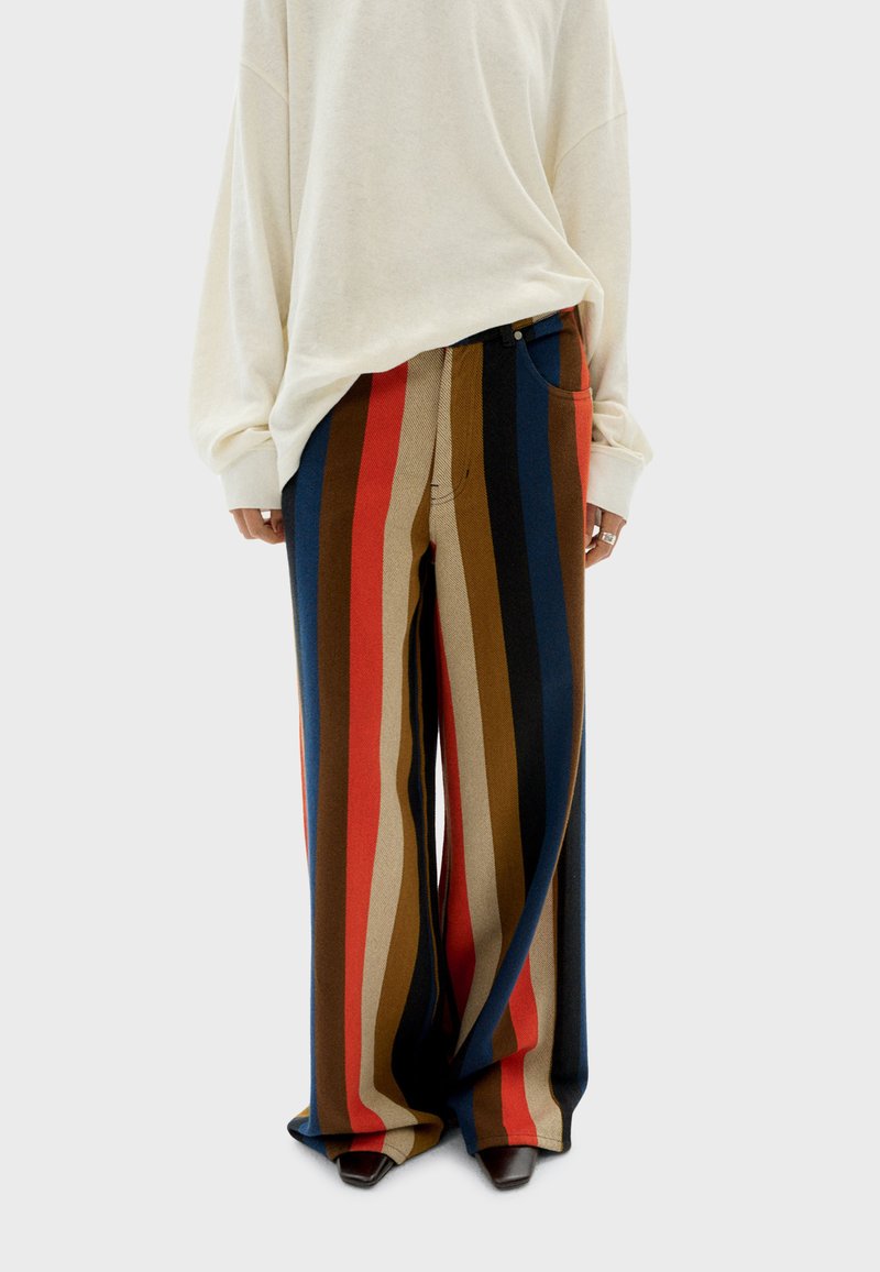 Weite Beinstreifen in Rot, Blau, Braun und Creme. Hergestellt aus einem weichen Stoff, verfügen sie über Seitentaschen und einen entspannten Schnitt.