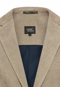 Beiger Blazer mit strukturierter Außenseite und glattem marineblauen Futter. Mit aufgesetzten Revers und einem schwarzen Etikett mit der Aufschrift "camel active", Größe 50.