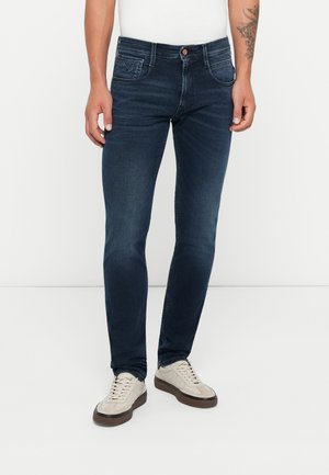 Mörkblå denimjeans med slim fit. Har en diskret fickdesign, lätt blekning och en enda kopparknapp i midjan.