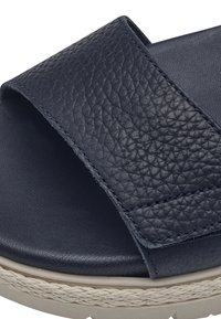 Infradito blu navy con tomaia in pelle testurizzata, soletta piatta e imbottita, e un accento in juta intrecciata attorno alla suola.