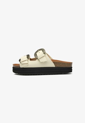 White leather slide sandal with two textured gray buckles, cork midsole, and black rubber outsole featuring a zigzag pattern.