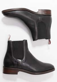 Bottes Chelsea en cuir noir avec panneaux latéraux élastiques, bout arrondi et talon en bois. Dotées d'une languette de tirage bordeaux et d'un logo de marque.