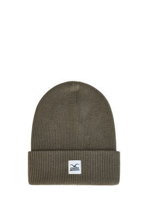 Dunkelgrüne, gerippte Strickmütze mit umgeschlagenem Bündchen und einem kleinen weißen rechteckigen Logo-Patch mittig auf dem Bündchen.