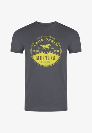 T-shirt en coton gris avec un graphique rond jaune affichant un logo de cheval et le texte "TRUE DENIM MUSTANG ORIGINAL ESTD 1932". Manches courtes.