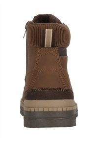 Bottine marron avec un cuir supérieur texturé, un col côtelé et une fermeture éclair latérale. Elle présente une semelle en caoutchouc et des détails de couture contrastants.