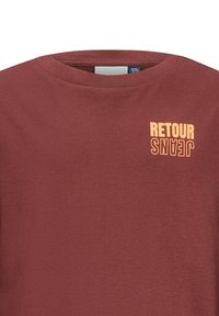 T-shirt di cotone color bordeaux con scollatura a girocollo e stampa "RETOUR JEANS" in arancione sul petto sinistro, con una texture liscia.