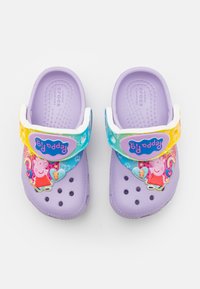 Zuecos de lavanda para niños con correas de arcoíris que presentan a Peppa Pig y diseños de corazones, arcoíris y estrellas coloridas.