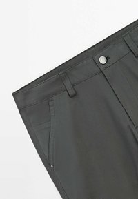 Dark gray tailored trousers made of smooth fabric, featuring belt loops, front pockets, and a metal button closure.