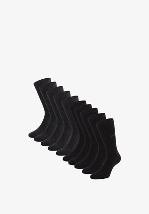 Dieci paia di calzini neri e grigio scuro lunghezza crew disposti in una linea diagonale su uno sfondo bianco.