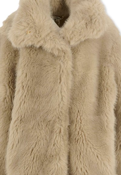 Cappotto in pelliccia sintetica beige con una superficie morbida e testurizzata, dotato di un ampio colletto e di un singolo bottone dorato decorativo alla scollatura.