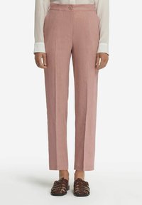 Ljusrosa raka byxor med textilstruktur, hög midja och dekorativ knäppning, tillsammans med mörkbruna sandaletter med remmar.