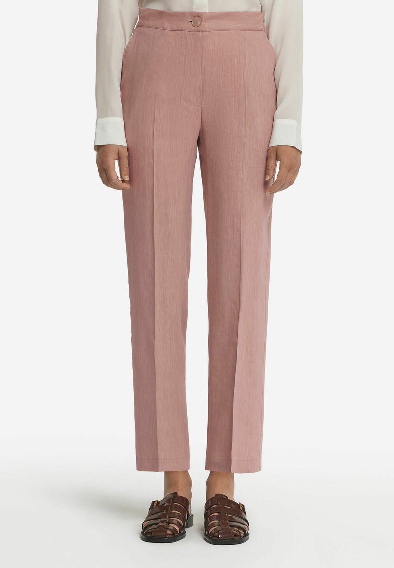 Ljusrosa raka byxor med textilstruktur, hög midja och dekorativ knäppning, tillsammans med mörkbruna sandaletter med remmar.