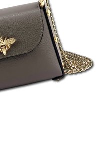 Gray leather handbag with a bee emblem, featuring a gold chain strap and textured finish. Compact rectangular shape with a flap closure.