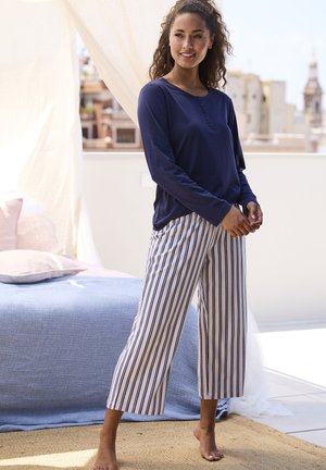 Marineblaues Langarmoberteil mit Knöpfen und gestreiften, weit geschnittenen Hosen in Weiß und Marineblau. Das Outfit zeichnet sich durch eine entspannte Passform und einen weichen Stoff aus.
