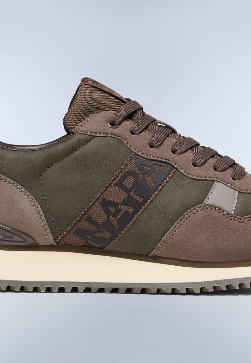 Zapatillas en marrón y verde oliva con un upper texturizado, destacado logo "NAPA", forma redondeada y suela de goma contrastante con un patrón de relieve.