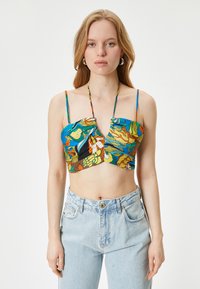 Top corto colorido con diseño en forma de v, estampados florales y abstractos en azul, amarillo y verde, con tirantes delgados y ajustables.