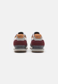 Men's sneakers in gray, burgundy, and orange. Features a mix of suede and mesh with "1973" embossed on the heel and a rubber sole.