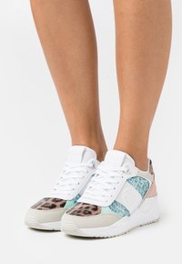 Hvide sneakers med en blanding af teksturerede materialer; har leopardprint, mintgrønne og blush-accenter, samt en polstret krave og snørebånddesign.