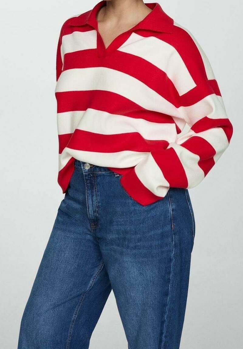 Personne portant une chemise à manches longues rayée rouge et blanche avec col, rentrée dans un jean en denim bleu à taille haute, main dans la poche.