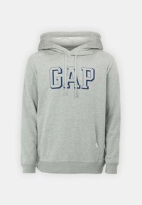 Sudadera con capucha de algodón gris que presenta un bolsillo canguro, mangas largas y una capucha con cordón. En el frente muestra "GAP" en letras azul marino.