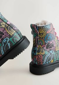 Czarne buty z kolorowym, dziecięcym wzorem przedstawiającym zwierzęta i kształty. Wykonane z teksturowanego materiału z gumową podeszwą i futerkiem syntetycznym w środku.