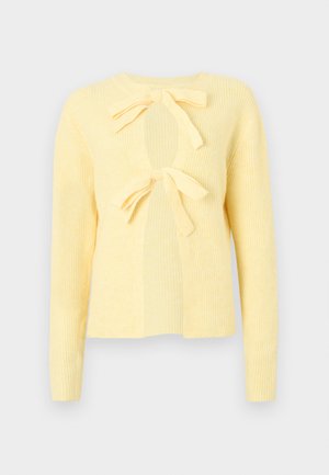Cardigan jaune côtelé à manches longues, doté de deux liens à l'avant et d'une découpe circulaire ouverte au niveau de la poitrine. Texture en maille douce.