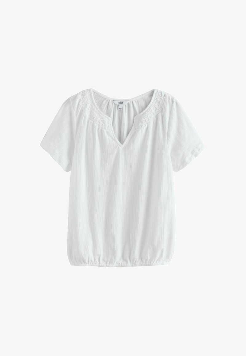 Bela kratka bluzica s kratkimi rokavi in V-izrezom, nabranim smokom na izrezu ter elastiko na robu. Iz lahkega teksturiranega blaga.