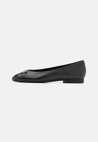 Zwarte ballerina's met een gepatineerde neus, een slanke leren bovenkant en een lage, vierkante hak. Een klein decoratief detail is aanwezig bij de neus.