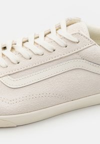 Beiger Wildleder-Sneaker mit Lederakzenten in Ton-in-Ton, rundem Zehenbereich und flachen Baumwollsenkeln. Verfügt über gestickte Details und einen strukturierten Schaft.