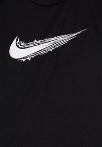Svart treningst-skjorte med en stor, hvit swoosh-logo med et teksturert, dynamisk design. Nærbilde viser stoffkvaliteten.