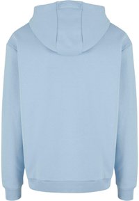 Svijetloplava dukserica s kapuljačom, glatke teksture, širokim manžetama i dizajnom za prebacivanje preko glave. Na leđima se nalazi središnje postavljena kapuljača.