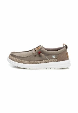 Zapato slip-on de lona marrón claro con una suela media de yute trenzado, suela exterior de goma blanca y pequeños acentos decorativos en el costado.