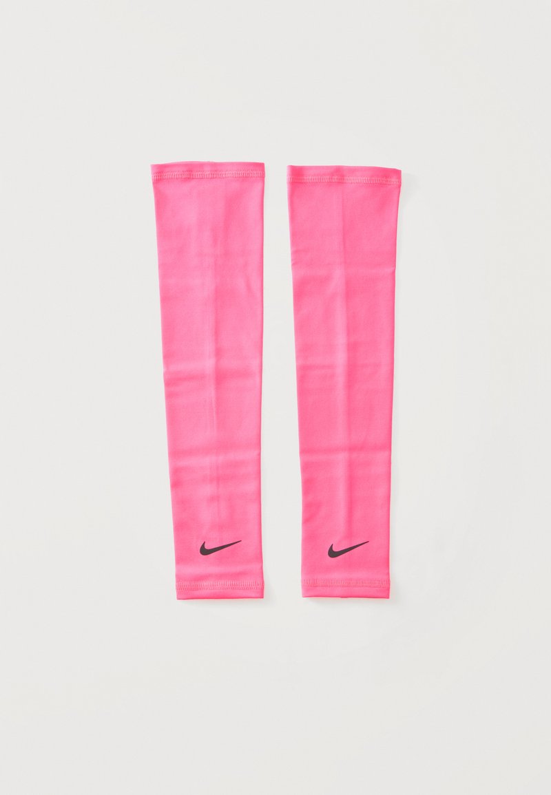 Paire de manchons de bras Nike rose vif posés à plat avec des logos Nike swoosh noirs près des poignets sur fond blanc.