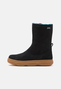 Czarny zamszowy botek za kostkę z miękką, miękką podszewką w kolorze niebieskozielonym, gumową podeszwą oraz pętelką z tyłu ułatwiającą zakładanie. Charakteryzuje się minimalistycznym przeszyciem.