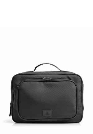 Sac de voyage noir en tissu durable, de forme rectangulaire, avec une poignée supérieure et une poche zippée à l'avant portant un logo.