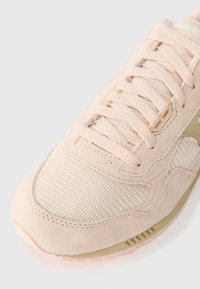 Helle beige Sneaker aus Wildleder und Mesh, mit strukturierten Akzenten, cremefarbenen Schnürsenkeln und einer schlanken Gummisohle mit dezentem Branding.