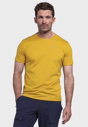 Gelbes kurzärmliges T-Shirt aus glattem Stoff, mit Rundhalsausschnitt und kleinem Logo auf der Brust. Getragen mit navyblauen Cargo-Hosen.