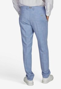 Lichtblauwe geruite broeken gemaakt van een lichtgewicht stof, met een getailleerde pasvorm, zijzakken en gedragen met witte sneakers.