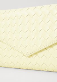 Woven yellow leather clutch w kształcie koperty, z gładką teksturą i ukośnym detalem przeszycia na powierzchni.