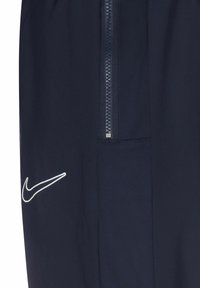 Marineblauwe sportshorts met een zip-pocket, mesh paneel en wit Nike-logo. Gemaakt van lichtgewicht, ademend materiaal.