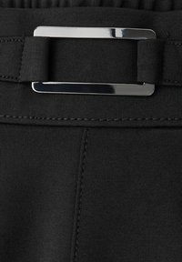 Schwarzer elastischer Taillenbund mit einem glänzenden metallischen Schnallendetail, glatter Textur und flachen Nähten entlang der Naht.