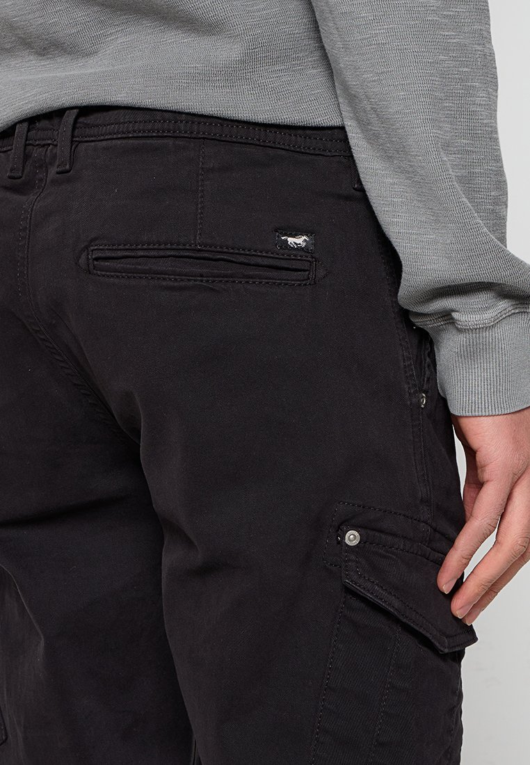 Zwarte cargobroek met een knoopsluiting zijzak, gestikte details en een klein geborduurd logo. Het materiaal heeft een gladde textuur.