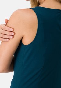 Miętowa, bezrękawnikowa bluzka o dopasowanym kroju, wykonana z miękkiego bawełnianego materiału, z delikatnymi detalami przeszycia wzdłuż ramion i bocznych szwów.