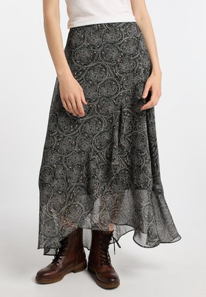 Zwarte paisley maxi rok van lichtgewicht stof, met ingewikkelde patronen en een vloeiende silhouet, gecombineerd met bruine veterlaarzen.