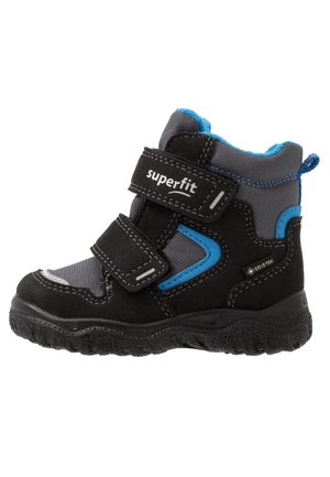 Botte d'hiver pour enfant noire et grise avec accents bleus, deux sangles Velcro, semelle texturée et étiquette imperméable Gore-Tex sur le côté.