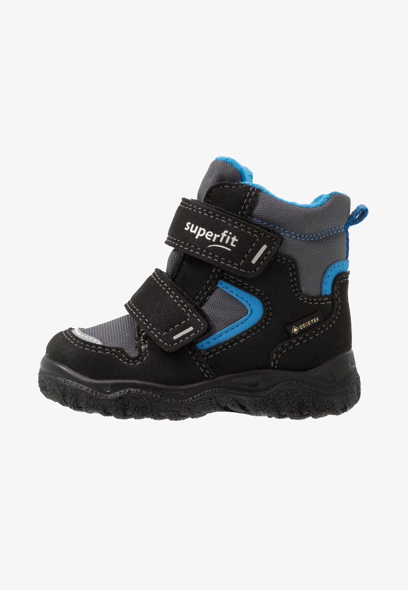 Botte d'hiver pour enfant noire et grise avec accents bleus, deux sangles Velcro, semelle texturée et étiquette imperméable Gore-Tex sur le côté.
