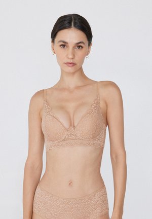 Beige Spitzen-BH mit floralem Muster, mit Unterstützung durch Bügel, verstellbaren Trägern und gewelltem Rand. Passender hoch taillierter Slip.