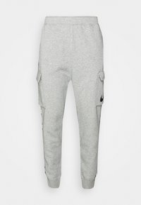 Grå mjukisbyxor i mjukt tyg, med sidofickor, avslutningar med resår och en svart logotyp på vänster ben.