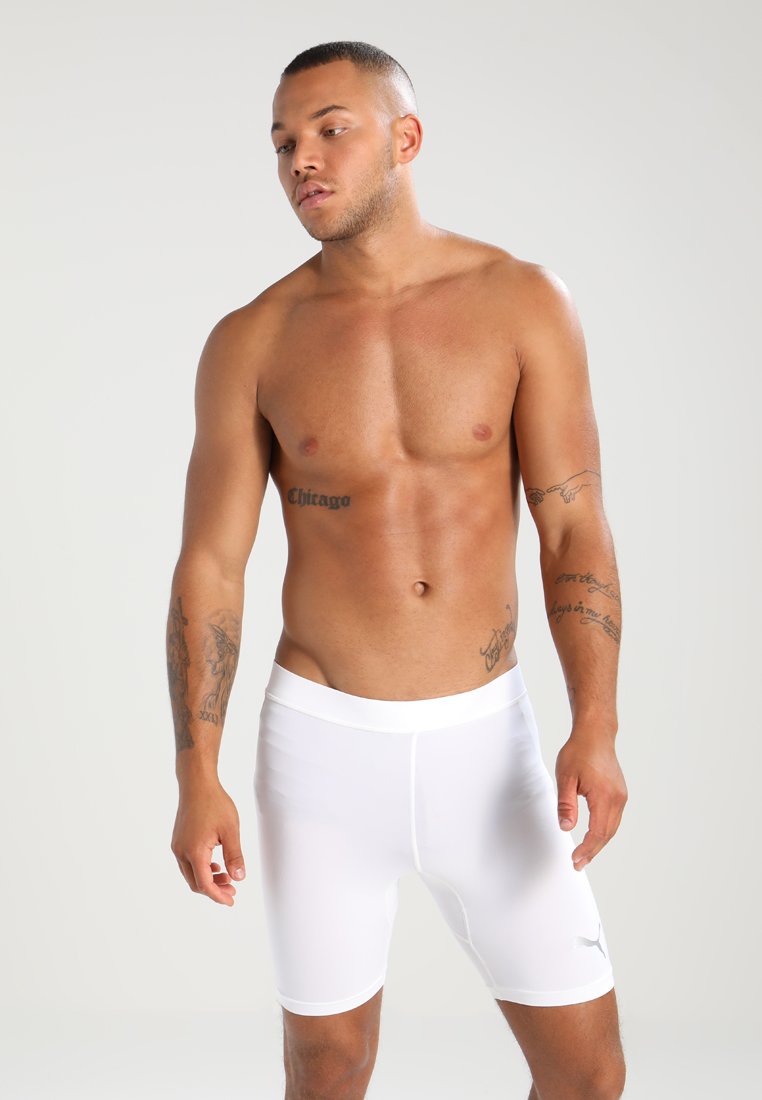 Hvite treningsshorts laget av elastisk stoff, med en tettsittende passform og en liten logo aksent på den nederste kanten. Glatt tekstur.