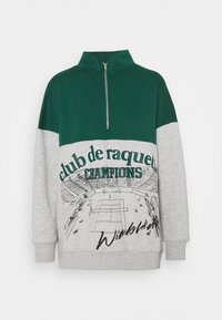 Zelená a šedá mikina se zipem do poloviny, s nápisem "club de raquette CHAMPIONS" a grafickým designem ve stylu Wimbledonu na přední straně.